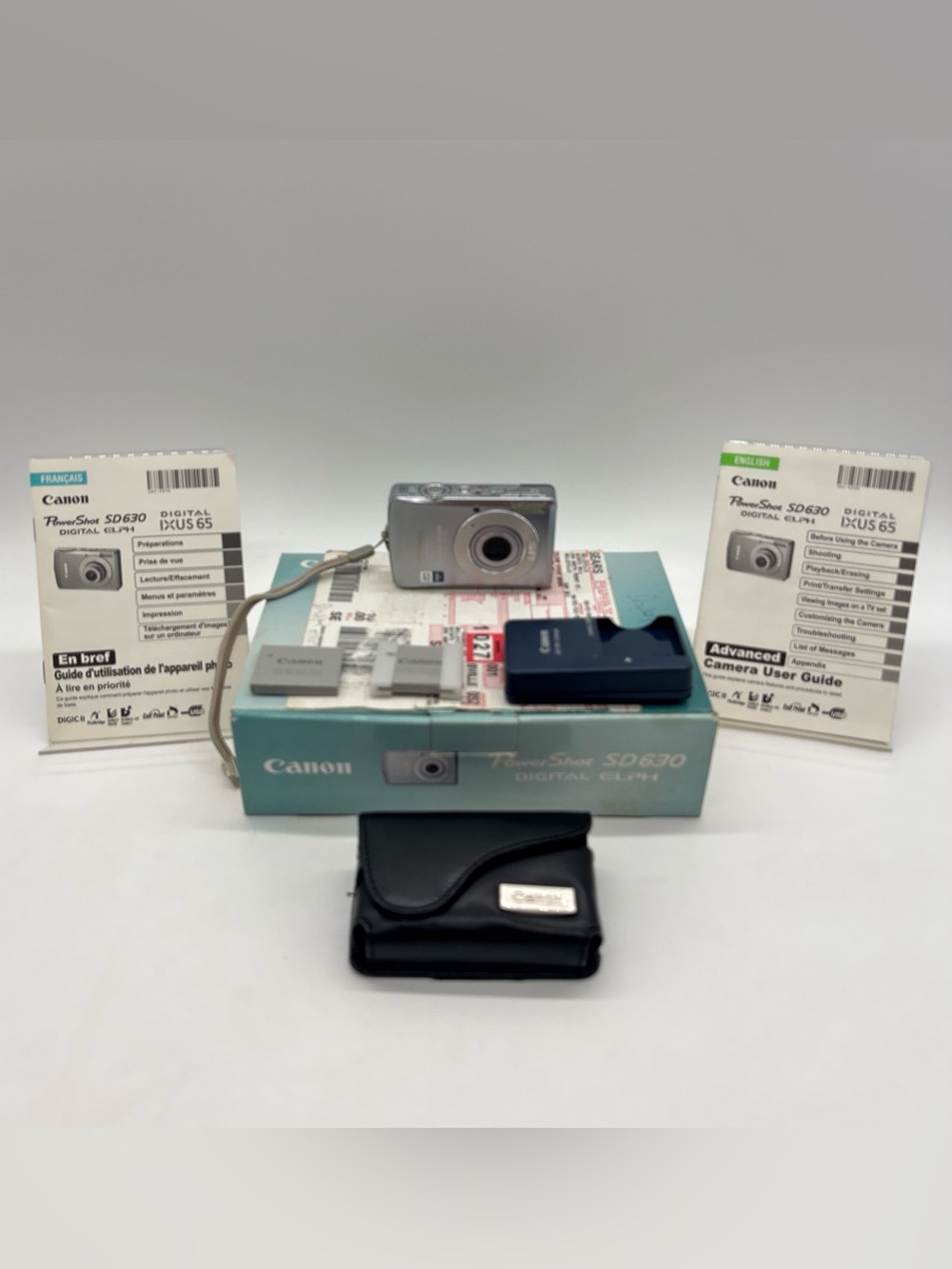Canon Silver Compact Digital Camera with Blue Accessory and Black Case